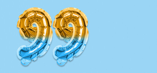 Rainbow foil balloon number, digit ninety nine on a blue background. Birthday greeting card with...