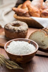 テーブルに並んだたくさんの種類のパンと小麦粉
