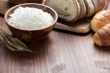 テーブルに並んだたくさんの種類のパンと小麦粉