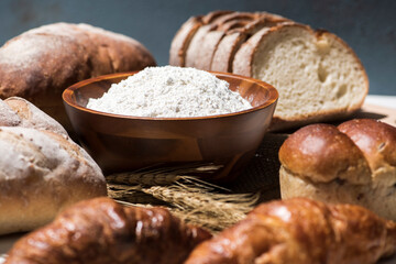テーブルに並んだたくさんの種類のパンと小麦粉