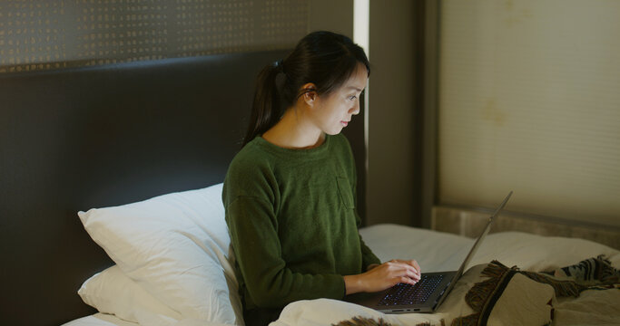 Woman Work On Laptop Computer On Bed At Night