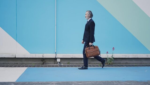 Cinematic 4k video footage of a successful senior Business man and sales person outdoor. Representation of professional expertise, financial and trading skills. Company ceo manager at work