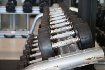 group of dumbbells lined up in the gym to be used. Healthy mind in a healthy body concept. Gymnastics, health.