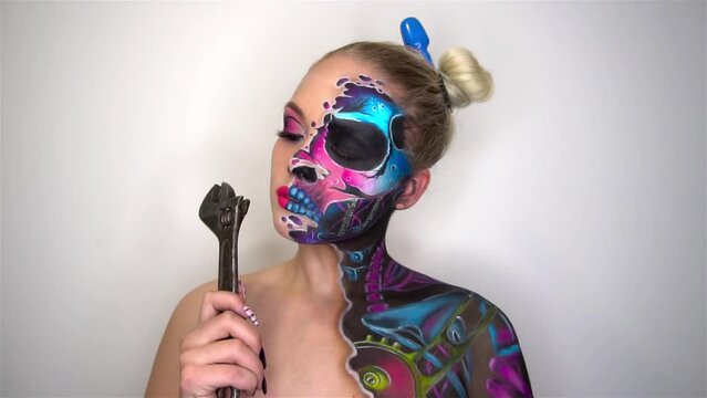 Slow Motion Young woman with scared halloween makeup holding a spanner