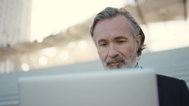 Cinematic 4k video footage of a successful senior Business man and sales person outdoor. Representation of professional expertise, financial and trading skills. Company ceo manager at work
