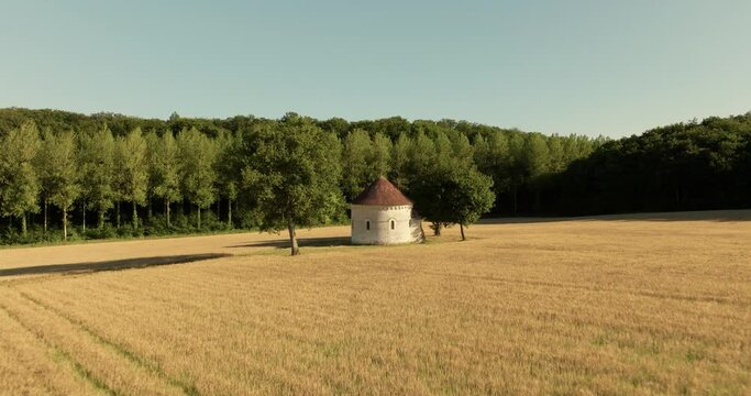 Aerial view of the chapel of the Liget next to wheat fields during sunset in France.
