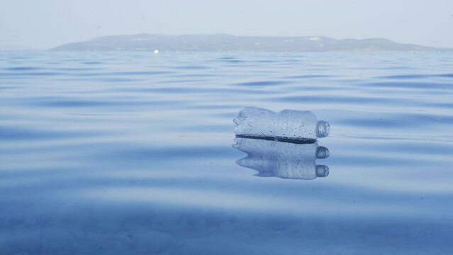 Plastic pollution of the sea. An empty plastic bottle floats in seawater. Contamination of the sea with waste is a bad ecology concept. Bottle Swinging on Waves. 