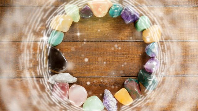 Animation of blinking dots and stars over stones bracelet on wooden background