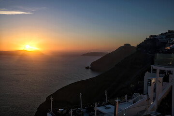View of a spectacular sunset and a cruise ship from the rooftops of Fira Santorini Greece