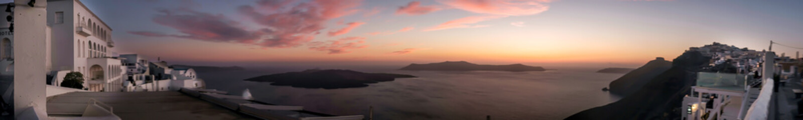 Panoramic view of the caldera, the volcano of Santorini and a beautiful colourful sky