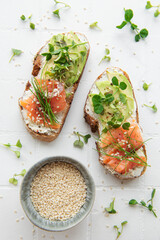 Sandwiches with salted salmon,  avocado and microgreens.