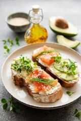 Sandwiches with salted salmon,  avocado and microgreens.