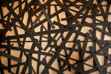 Many black rectangular stripes are scattered on a wooden background.