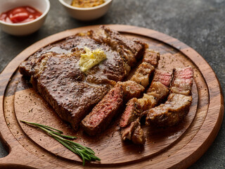 Medium rare Ribeye steak or beef steak on the wooden tray with herbs
