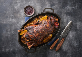 Griddle-roasted goose with baked apples on gray background, festive holiday recipe