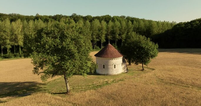Aerial view of the chapel of the Liget next to wheat fields during sunset in France.