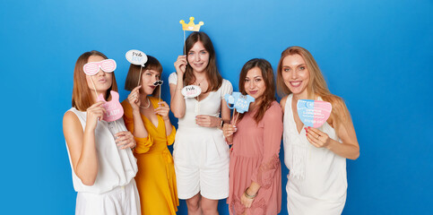 Front image of a group of joyful women to have gender reveals envent, isolated blue background....