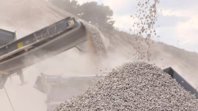 Stone crushing machine at open pit mining and processing plant for gravel stone. Piles of crushed stone and conveyor belts. Concepts of industry and building materials, sand and gravel, slow motion