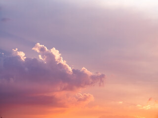 Fototapeta premium Cloudy sky during thunderstorm. Cumulus clouds shines orange and pink at the horizon during the weather changes. Weather, clouds, temperature and meteorology.