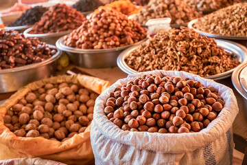 hazelnuts in shell, walnut and other nuts and dried fruits and raisins on the farmers counter at...
