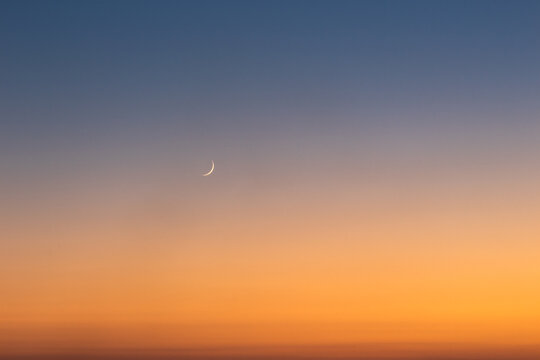 Sunset on clear sky with moon and the star.