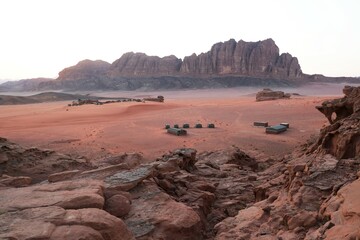 Amazing scenery of Wadi Rum Desert looks like Mars. Bedouin tents in valley. Jabal Al Qatar mountain on horizon.