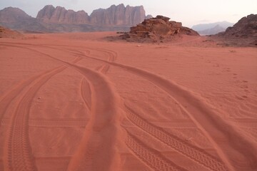 Amazing scenery of Wadi Rum Desert looks like Mars. Traces of off-road car tires on red sand.