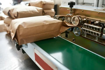 Foto op Plexiglas Pack machine with paper package of coffee beans © Svitlana