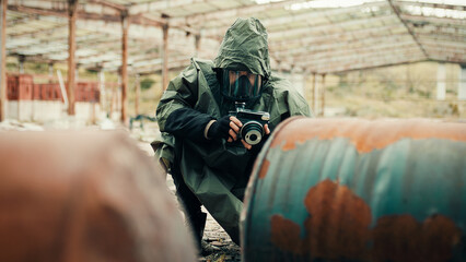 man with gas mask photographs the radioactive barrels