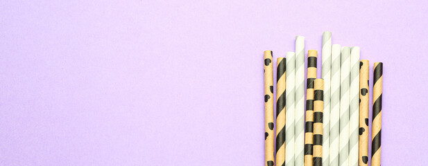 Stylish straws for cocktails on lilac background with space for text
