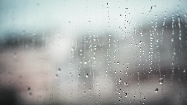 A handheld cinematic shot of raindrops running down the window