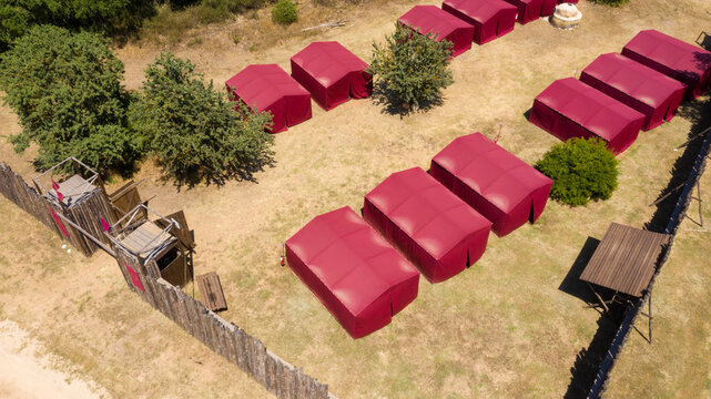 Historical reconstruction of a military camp of ancient Rome. The red curtains were iconic of the Roman army. Aerial view.