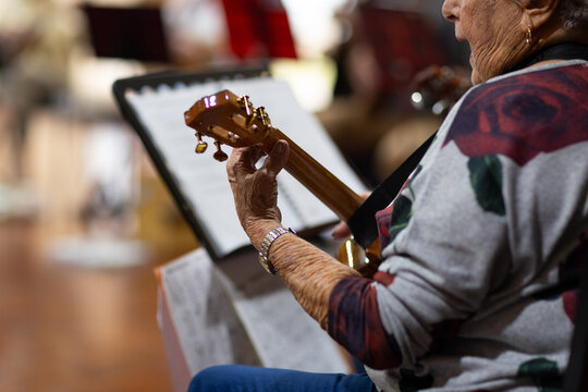 detail of elderly lady playing ukulele