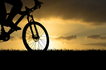 Silhouettes of mountain bikes and cyclists in the evening happily. Travel and fitness concept....