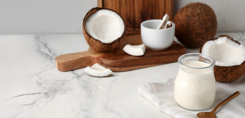 Jar of tasty coconut yogurt on light background