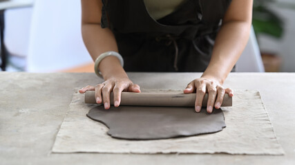 Young woman creating handmade ceramic bowl in workshop. Indoors lifestyle activity, handicraft, hobbies concept