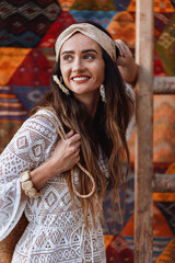 Portrait of a beautiful girl in a white dress near the Moroccan carpet. Essaouira. Morocco