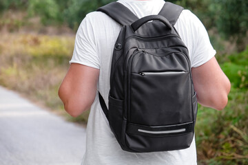 Young male traveler with modern backpack outdoors, back view