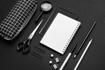 Pencil case and different stationery on dark background