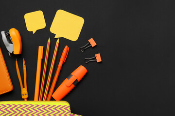 Pencil case and different stationery on dark background