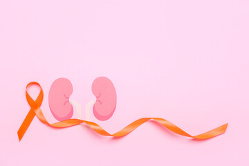 Orange awareness ribbon and paper kidneys on pink background