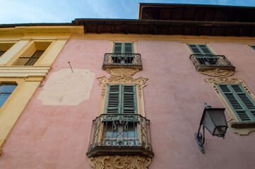 Fototapeta na wymiar Detail of the nice pastel colored facade of an historical residencial building in Orta san Giulio, Piedmont, Italy. 