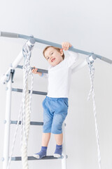 child boy on the Swedish wall or sports complex climbs at home, the concept of children's sports