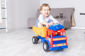 Fototapeta premium baby boy sitting or riding in a typewriter at home, the concept of a child's game