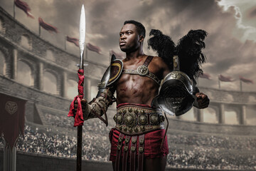 Portrait of victorious gladiator of african ethnic holding plumed helmet and spear in coliseum. - obrazy, fototapety, plakaty