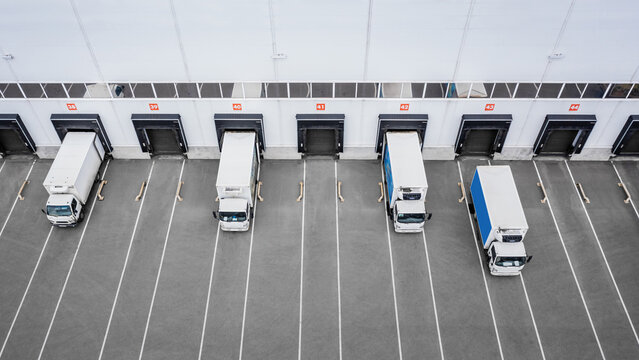 Small trucks unloading in distribution hub. Aerial view
