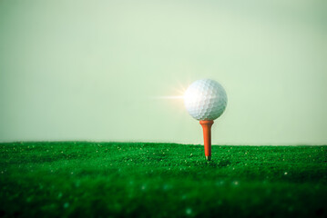 Close-up shot of golf ball on the hitting platform Golf ball on red hitting platform on beautiful green grass. Sports that people around the world play during their holidays for health.