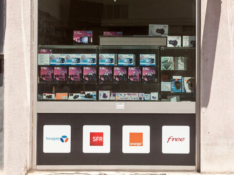 LYON, FRANCE - JULY 15, 2016: Logos of the four telecom operators, competitors & mobile phone carriers of France in front of a telephone shop: Bouygues Telecom, SFR, Free and Orange