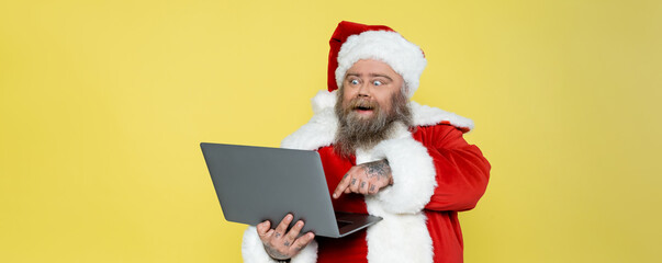 excited plus size man in christmas costume pointing at computer isolated on yellow, banner.