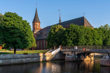 Fototapeta na wymiar View of the Koningberg Cathedral on Immanuel Kant Island against the background of the Honey Bridge over the Pregolya River on a sunny summer day, Kaliningrad, Russia